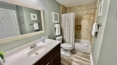 a bathroom with a sink and a toilet and a mirror at Tropic Winds 904 in Panama City Beach