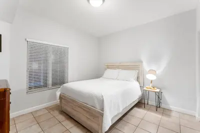a white bedroom with a bed and a window at Shores Of Panama #2101 in Panama City Beach