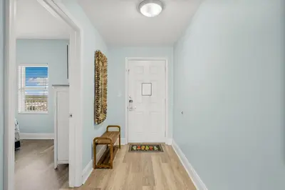 a hallway with a white door and a chair at Laketown Wharf #1517 by Nautical Properties in Panama City Beach
