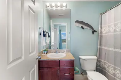 a bathroom with a sink and a toilet and a mirror at Laketown Wharf #1022 in Panama City Beach