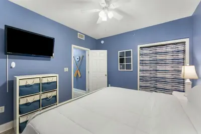 a blue bedroom with a bed and a flat screen tv at Laketown Wharf #0606 in Panama City Beach