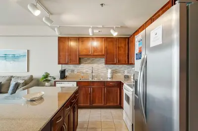 a kitchen with wooden cabinets and a stainless steel refrigerator at Laketown Wharf #0702 in Panama City Beach