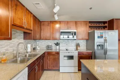 a kitchen with wooden cabinets and white appliances at Laketown Wharf #0702 in Panama City Beach