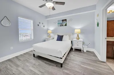 a bedroom with a white bed and a window at Laketown Wharf 1120 by Emerald Coast Retreats in Panama City Beach