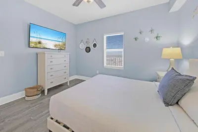 a bedroom with a bed and a dresser with a tv at Laketown Wharf 1120 by Emerald Coast Retreats in Panama City Beach
