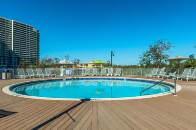 a swimming pool on a deck with chairs around it at Laketown Wharf 1120 by Emerald Coast Retreats in Panama City Beach