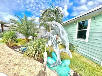 a dolphin statue in front of a house at 2 Fins Up, Beach Home, Private Pool , Golf Cart, 6 beds in Panama City Beach