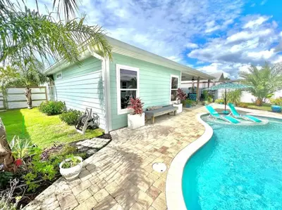 a house with a swimming pool in front of a house at 2 Fins Up, Beach Home, Private Pool , Golf Cart, 6 beds in Panama City Beach