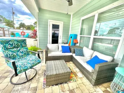 a patio with a couch and chairs on a house at 2 Fins Up, Beach Home, Private Pool , Golf Cart, 6 beds in Panama City Beach