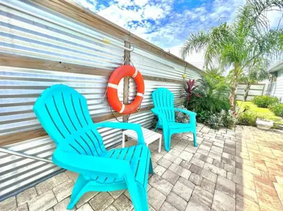 two blue chairs and an orange lifesaver on a patio at 2 Fins Up, Beach Home, Private Pool , Golf Cart, 6 beds in Panama City Beach