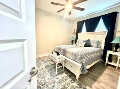 a bedroom with a bed and a ceiling fan at 2 Fins Up, Beach Home, Private Pool , Golf Cart, 6 beds in Panama City Beach