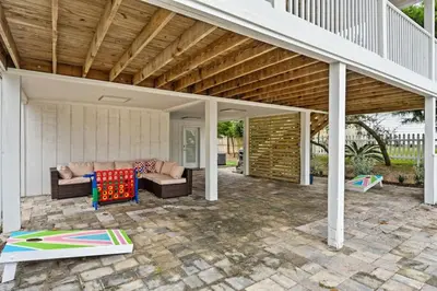 an outdoor patio with a couch and a table at Nest & Nook, Hot Tub, Fire pit, Deck, Yard, close to lake in Panama City Beach