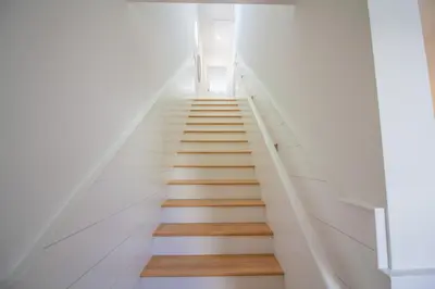 a staircase in a house with white walls and wooden floors at POOL | Heart & Soul Luxury | Walk to Beach in Inlet Beach