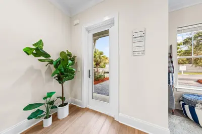 a white room with a door and plants at Walk to Beach! Sleeps 18 - 10 beds in Rosemary Beach