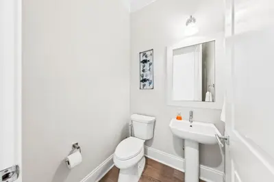 a white bathroom with a toilet and a sink at Walk to Beach! Sleeps 18 - 10 beds in Rosemary Beach
