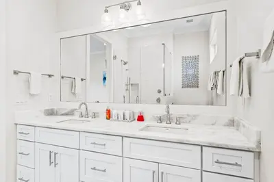 a white bathroom with two sinks and a large mirror at Walk to Beach! Sleeps 18 - 10 beds in Rosemary Beach