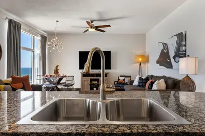 a kitchen with a sink and a living room at 707 Sterling Reef in Panama City Beach