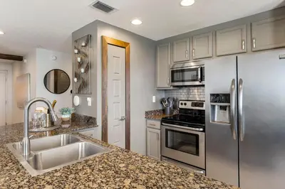 a kitchen with stainless steel appliances and granite counter tops at 707 Sterling Reef in Panama City Beach