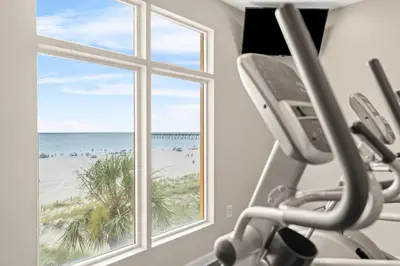 a gym with a view of the beach from a window at 707 Sterling Reef in Panama City Beach