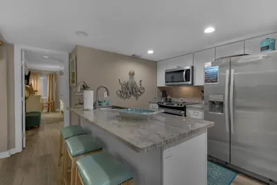 a kitchen with a counter and a refrigerator at Sugar Beach C1 in Panama City Beach