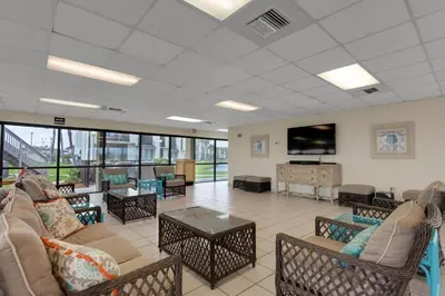 a living room with couches and a flat screen tv at Sugar Beach C1 in Panama City Beach