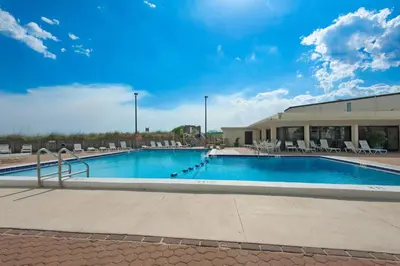 a large swimming pool with chairs and a building at Sugar Beach C1 in Panama City Beach