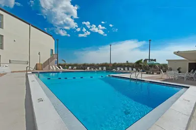 a large swimming pool with blue water in front of a building at Sugar Beach C1 in Panama City Beach