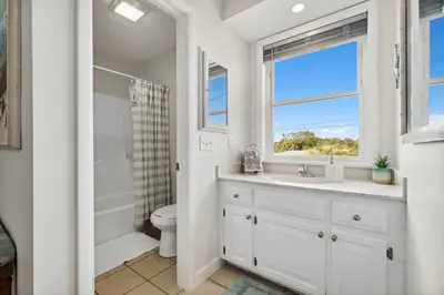 a bathroom with a sink and a toilet and a window at 9614 Beach Blvd in Panama City Beach