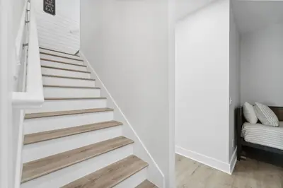 a staircase in a house with white walls and wood floors at Grand Retreat I! 4BR 5BA Sleeps 15! Private Pool! Luxury and comfort await! in Panama City Beach
