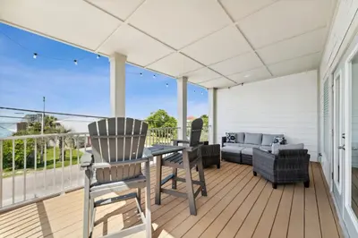 a patio with a table and chairs on a deck at Grand Retreat I! 4BR 5BA Sleeps 15! Private Pool! Luxury and comfort await! in Panama City Beach