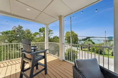 a porch with a chair and a table at Grand Retreat I! 4BR 5BA Sleeps 15! Private Pool! Luxury and comfort await! in Panama City Beach