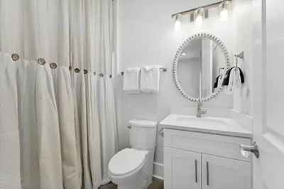 a bathroom with a toilet and a sink and a mirror at Grand Retreat I! 4BR 5BA Sleeps 15! Private Pool! Luxury and comfort await! in Panama City Beach
