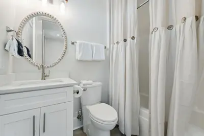 a bathroom with a toilet and a sink and a mirror at Grand Retreat II: 4BR, 5BA, sleeps 15 Private pool Your perfect escape! in Panama City Beach