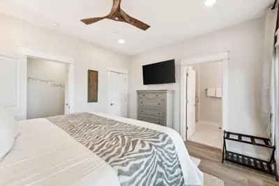 a bedroom with a bed and a flat screen tv at Grand Retreat II: 4BR, 5BA, sleeps 15 Private pool Your perfect escape! in Panama City Beach