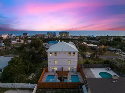 an aerial view of a house and the ocean at sunset at Grand Retreat II: 4BR, 5BA, sleeps 15 Private pool Your perfect escape! in Panama City Beach