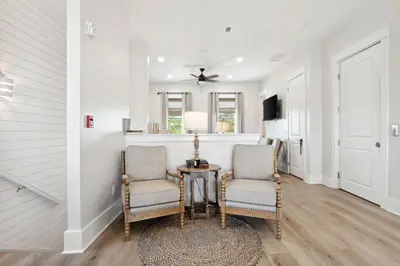 a living room with two chairs and a table at Grand Retreat II: 4BR, 5BA, sleeps 15 Private pool Your perfect escape! in Panama City Beach