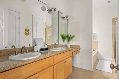 a bathroom with two sinks and a large mirror at Modern Beach Haüs 4 min walk to beach w/ pool BBQ in Panama City Beach