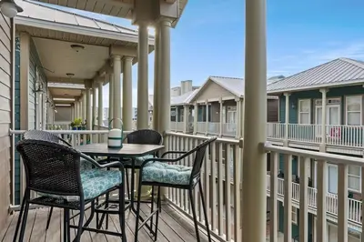 a patio with chairs and a table on a balcony at Modern Beach Haüs 4 min walk to beach w/ pool BBQ in Panama City Beach