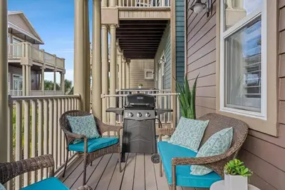 a patio with chairs and a grill on a house at Modern Beach Haüs 4 min walk to beach w/ pool BBQ in Panama City Beach