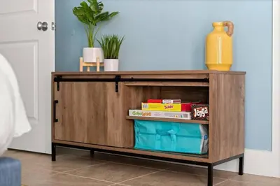 a wooden cabinet with books on it in a room at Modern Beach Haüs 4 min walk to beach w/ pool BBQ in Panama City Beach