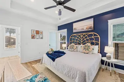 a bedroom with a large bed with a blue wall at Sand Castle in Panama City Beach
