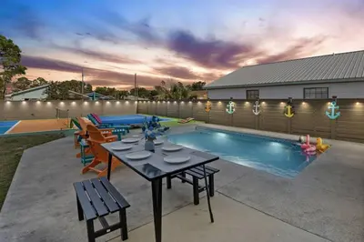 a backyard with a table and a swimming pool at Sand Castle in Panama City Beach
