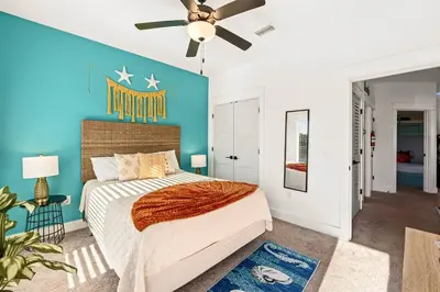 a bedroom with a king sized bed and a blue wall at Sand Castle in Panama City Beach