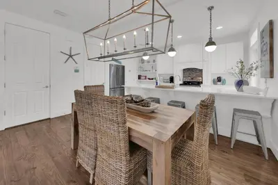 a kitchen and dining room with a wooden table and chairs at The Java House in Rosemary Beach