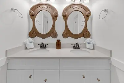 a bathroom with two sinks and two mirrors at The Java House in Rosemary Beach
