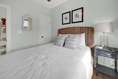 a bedroom with a bed and a table with a lamp at The Java House in Rosemary Beach