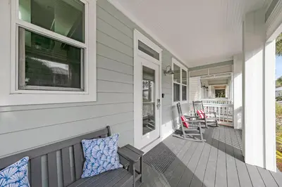 a porch of a house with two pillows on it at The Java House in Rosemary Beach