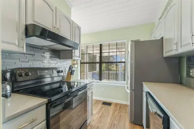 a kitchen with stainless steel appliances and white cabinets at Solitude on 30A - Seacrest Beach - Beach Access in Rosemary Beach