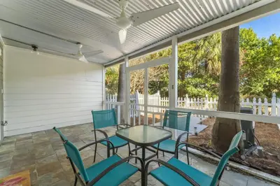 a patio with chairs and a table and a fireplace at Solitude on 30A - Seacrest Beach - Beach Access in Rosemary Beach