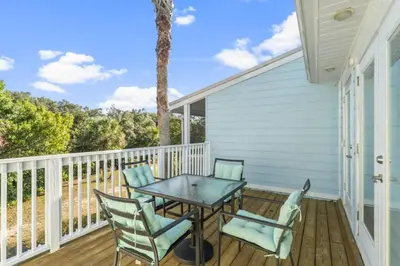a patio with a table and chairs on a deck at Solitude on 30A - Seacrest Beach - Beach Access in Rosemary Beach